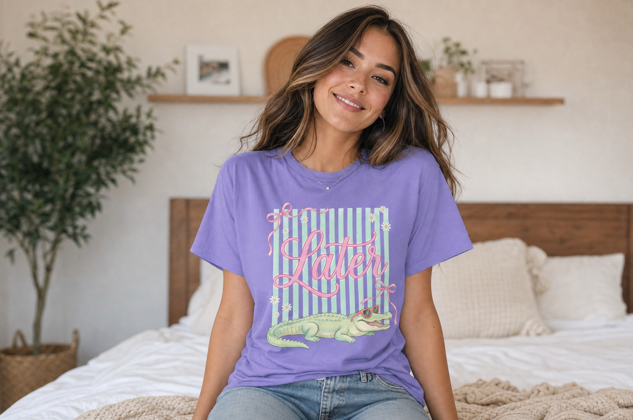 A young woman wearing a purple t-shirt with a graphic of a green alligator and the text "Loser" is sitting on a bed in a bedroom.