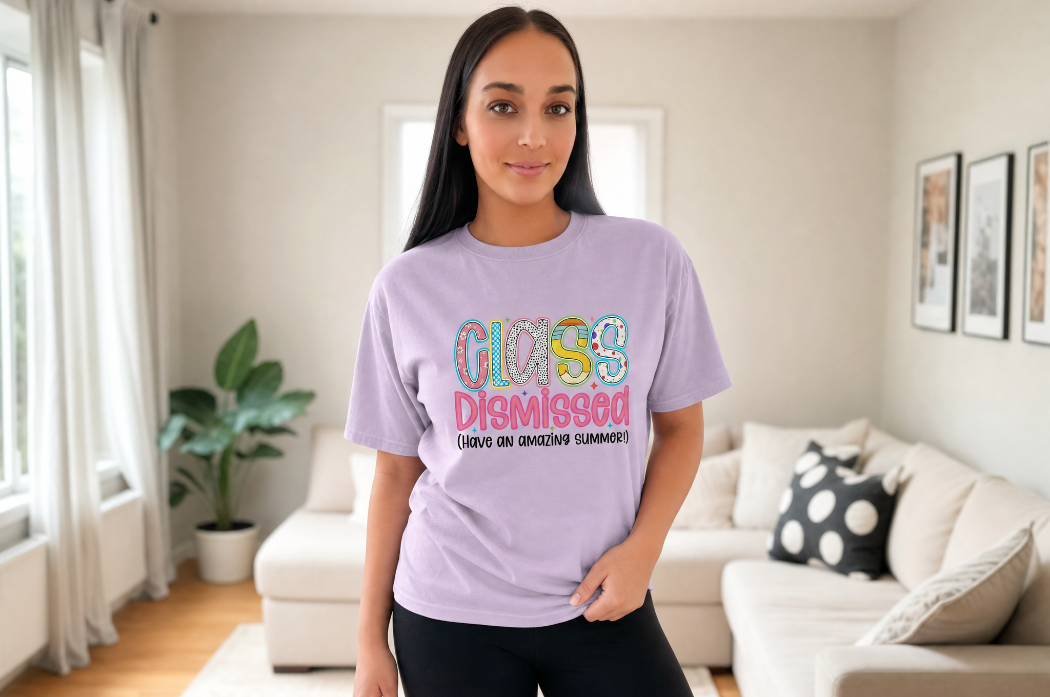 A woman wearing a purple t-shirt with a colorful graphic design stands in a living room.