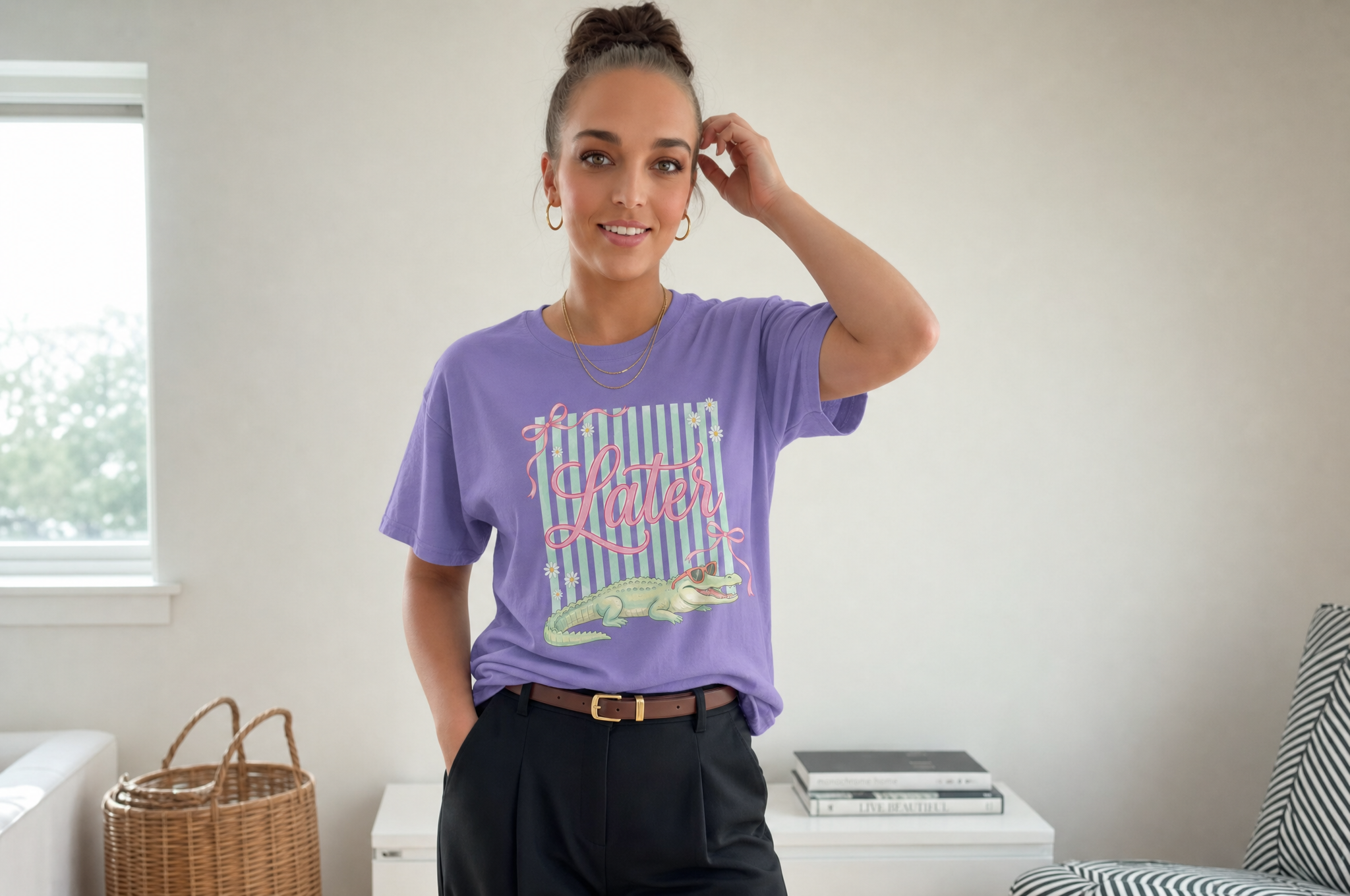 A woman wearing a purple t-shirt with a graphic design stands in a room with a window and a basket.